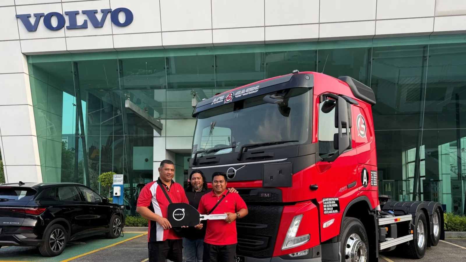 Representatives from Ace Gases and Volvo Trucks Malaysia holding a ceremonial key mockup in front of a red Volvo FM 450 6x2 prime mover. (Photo: Volvo Trucks Malaysia/LinkedIn)